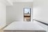 Bright and inviting bedroom with large window offering a serene view, perfect for relaxation and comfort.