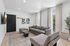 Modern and inviting living room with a plush gray sofa, chic decor, and abundant natural light filtering through large windows.