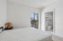 Bright and airy bedroom with a large window, cozy bedside table, and an ensuite bathroom for ultimate convenience.