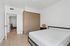 Elegant bedroom with a minimalist design, featuring a sleek wooden wardrobe, a modern bed, and a stylish bedside lamp.