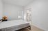 Bright minimalist bedroom with ensuite bathroom, featuring sleek modern design and natural light.