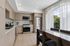 Modern kitchen with sleek cabinetry, stainless steel appliances, and large windows offering abundant natural light.