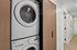 Modern apartment hallway featuring a sleek, built-in washer and dryer with chic wooden cabinetry for a seamless look.