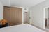 Contemporary bedroom with sleek built-in wardrobe, cozy lighting, and inviting neutral tones.
