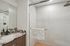 Elegant bathroom featuring a sleek marble countertop, modern shower with glass doors, and luxurious fixtures.