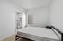 Modern bedroom with ensuite bathroom, featuring sleek minimalistic design and abundant natural light.