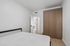Modern bedroom featuring sleek wooden wardrobe, minimalist design, and calming neutral tones for a serene ambiance.
