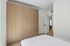 Modern bedroom showcasing sleek built-in wooden wardrobes and minimalist design.