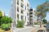Modern apartment building with sleek design, large windows, and lush landscaping, set on a sunny, tree-lined street.