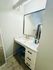 Chic bathroom vanity featuring a marble countertop, large illuminated mirror, and ample storage.