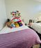 Cozy bedroom decorated with plush toys, colorful postcards, and a comfy bed setting.