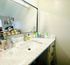 Beautiful bathroom featuring a marble countertop, modern faucet, and a large mirror.