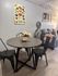 Cozy dining area with modern round table, black chairs, and floral centerpiece in a stylish apartment.