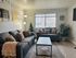 Inviting living room with comfortable seating, elegant decor, and a large window letting in natural light.