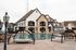 Luxurious apartment complex showcasing a pristine swimming pool, stylish outdoor seating, and elegant stone architecture.
