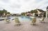 Luxurious resort-style pool area with stylish lounge chairs and beautiful palm trees, perfect for a relaxing getaway.