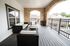 Elegant and spacious balcony with stylish wicker furniture and stone archways offering scenic views.