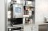 Modern kitchen nook with a sleek coffee machine, variety of coffee packs, and a stylish white marble backsplash.