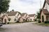 Charming suburban neighborhood with picturesque townhouses, lush greenery, and inviting sidewalks.