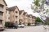 Charming residential apartment complex with stone facades, lush landscaping, and ample parking, nestled in a serene neighborhood setting.