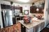 Modern kitchen with elegant granite countertops, stainless steel appliances, and stylish dark wood cabinetry, creating a cozy and inviting cooking space.