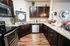 Chic kitchen with rich dark wood cabinetry, sleek stainless steel appliances, and elegant granite countertops, ideal for modern living.