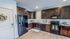 Modern kitchen with sleek dark wood cabinets, stainless steel appliances, and elegant decor accents.