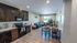 Contemporary open-concept kitchen and living room with sleek dark cabinetry, cozy sectional sofa, and abundant natural light.