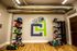 Contemporary fitness room featuring colorful exercise equipment, sleek storage racks, and a stylish wall mural with a logo.