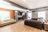 Modern, spacious living room with sleek hardwood floors, cozy seating, and a stylish fireplace, perfect for entertaining.