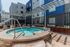Modern apartment courtyard featuring a chic round hot tub surrounded by cozy seating and stylish landscaping.