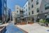 Modern apartment courtyard featuring sleek architecture, comfortable seating, and string lights for an inviting atmosphere.