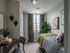 Chic bedroom with cozy single bed, stylish decor, and a window view, perfect for relaxation.