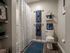 Inviting bathroom featuring elegant decor with a cozy shower curtain, blue patterned towels, and decorative shelving for a touch of sophistication.