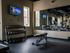 Inviting fitness center with modern gym equipment, mirrored walls, and a wall-mounted TV, perfect for energized workouts.
