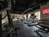 Modern fitness center with state-of-the-art equipment, including treadmills, weight machines, and free weights, in a well-lit space with large windows.