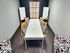 Chic meeting room with modern decor, featuring a long white table, stylish wooden chairs with patterned cushions, and colorful accent seating.