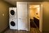 Modern apartment featuring an in-unit washer and dryer next to a sleek bathroom with wood flooring and elegant lighting.