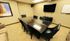 Elegant conference room with a sleek glass table, modern black chairs, large flat-screen TV, and tasteful artwork, ideal for productive meetings.