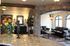 Charming lobby with a cozy leather seating area, rustic stone archways, and vibrant floral arrangement.