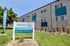 Vibrant student housing with stylish facade, lush landscaping, and prominent Now Leasing banner.