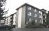 Modern apartment exterior with sleek siding, large windows, and lush landscaping, offering a welcoming and contemporary living space.