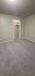 Spacious bedroom with plush carpet and a walk-in closet, offering comfort and ample storage.