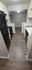 Modern galley kitchen with sleek black appliances, elegant countertops, and bright white cabinetry, offering a stylish and functional cooking space.