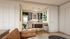 Inviting open-concept kitchen with sleek countertops, stylish bar stools, and vibrant artwork, perfect for modern living.