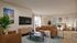 Sophisticated living space featuring modern brown leather sofas, elegant wall art, and a cozy bedroom area with natural light and lively plants.