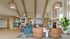 Inviting living space with vaulted ceilings, modern furnishings, and natural lighting, featuring a cozy seating area and stylish kitchen.