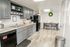 Modern kitchen with sleek gray cabinets, stainless steel sink, and cozy dining area, perfect for family meals.