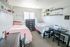 Charming shared bedroom with two cozy twin beds, stylish shelving, and a well-lit study desk, perfect for comfort and productivity.