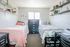 Cozy bedroom with two twin beds, stylish wall shelves, and bright natural light.